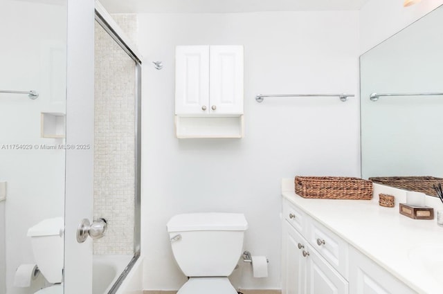 bathroom with shower / bath combination with glass door, vanity, and toilet