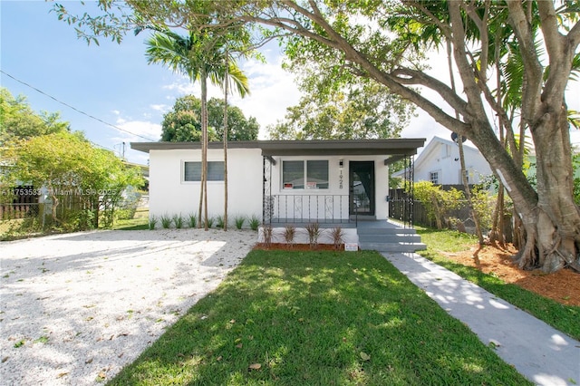 bungalow-style house featuring a front lawn, fence, a porch, and stucco siding