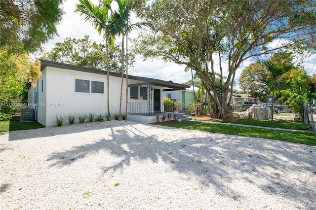 single story home with central air condition unit, fence, a porch, and stucco siding