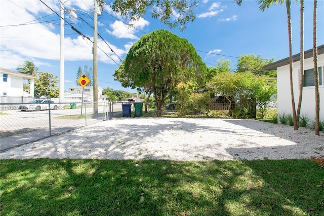 view of community with a lawn and fence