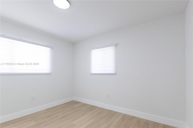 unfurnished room featuring baseboards and light wood-style floors