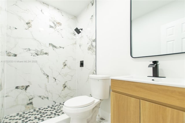 full bathroom featuring toilet, a marble finish shower, and vanity