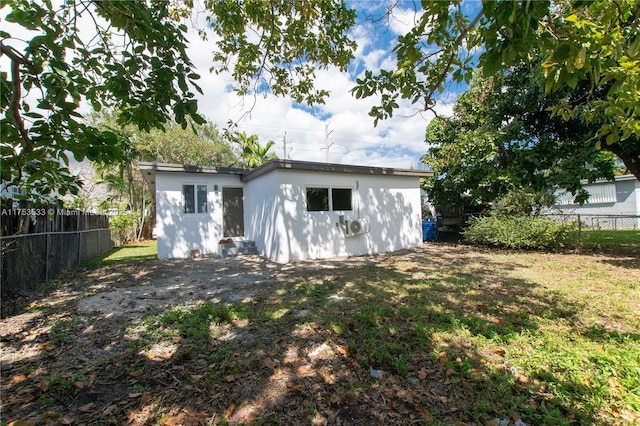 back of house with a fenced backyard and a lawn