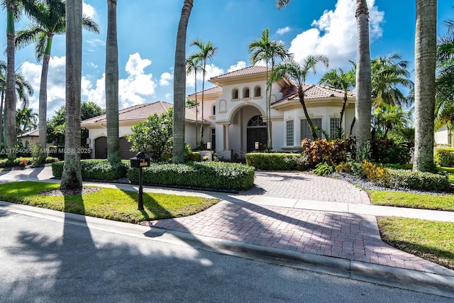 mediterranean / spanish home with stucco siding and a tiled roof