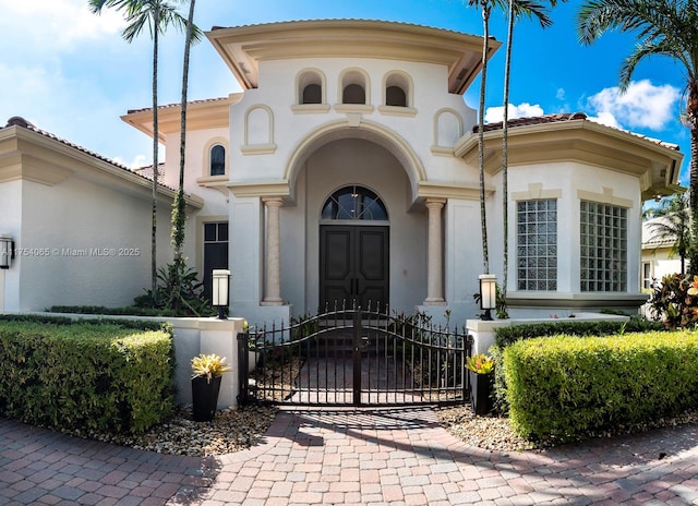 property entrance with a gate and stucco siding