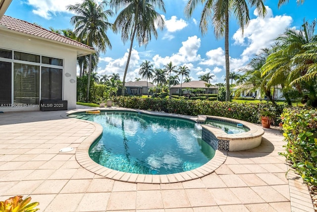 view of swimming pool featuring a pool with connected hot tub and a patio