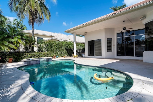 view of swimming pool featuring a patio, a pool with connected hot tub, and a ceiling fan