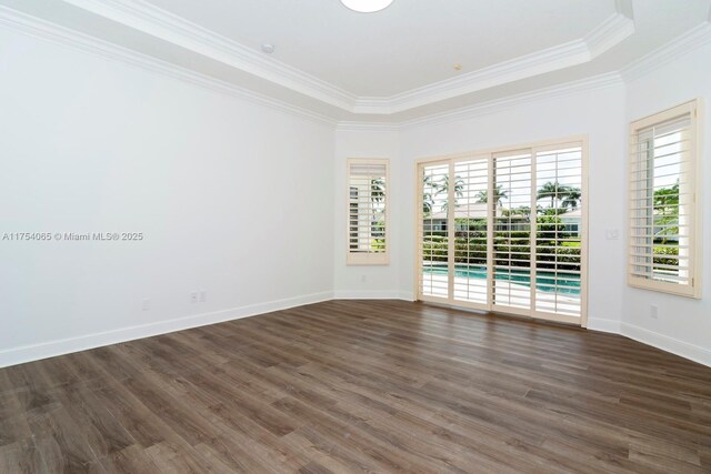 unfurnished room with dark wood-style flooring, crown molding, and baseboards