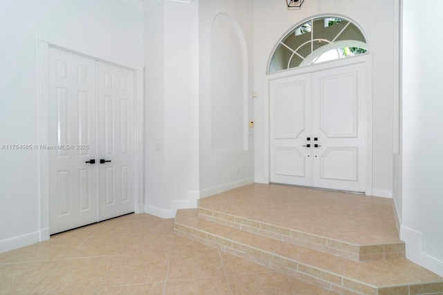 tiled foyer featuring baseboards