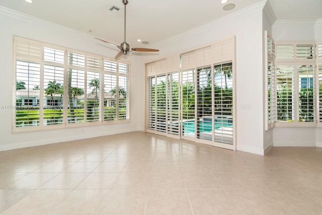 tiled empty room featuring baseboards, visible vents, crown molding, and ceiling fan