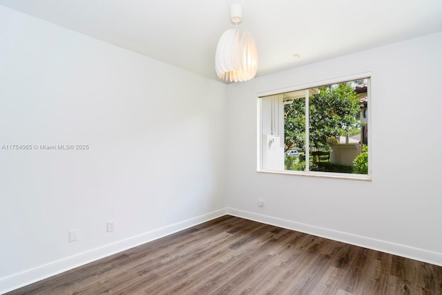 unfurnished room with baseboards and wood finished floors