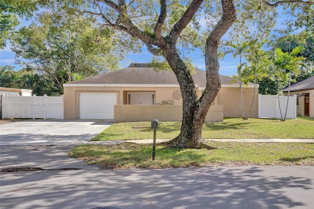 ranch-style home featuring stucco siding, fence, a garage, driveway, and a front lawn