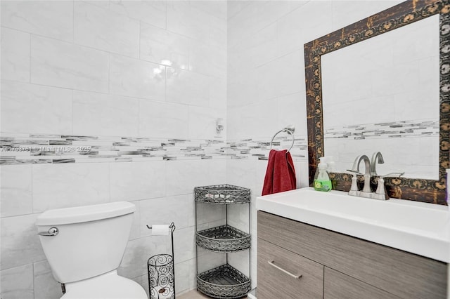 bathroom with toilet, tile walls, and vanity