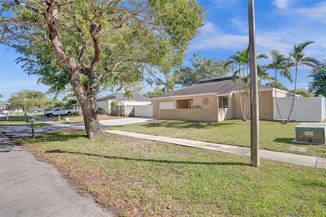 view of front of home featuring a garage, driveway, fence, and stucco siding