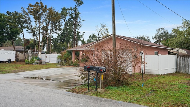 view of side of home with fence, a lawn, and stucco siding