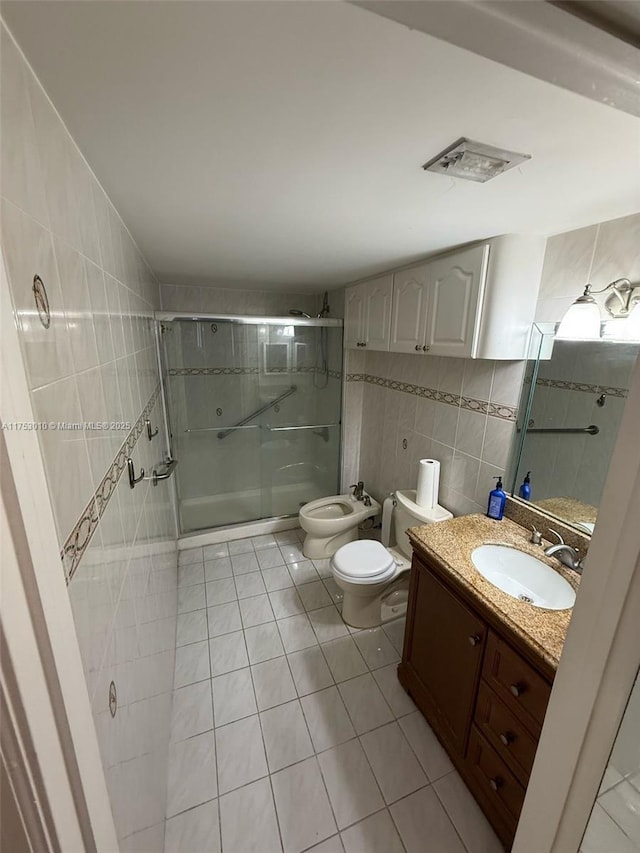 full bath featuring tile walls, visible vents, a bidet, a shower stall, and vanity