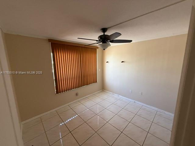 unfurnished room featuring a ceiling fan and light tile patterned flooring