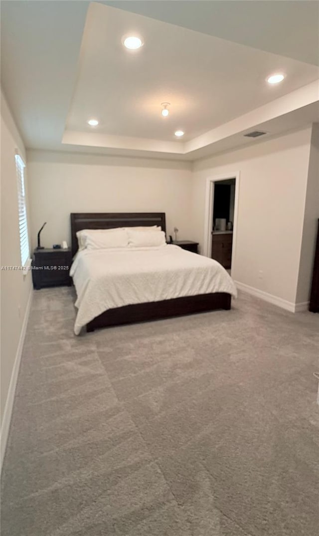 carpeted bedroom featuring recessed lighting, a raised ceiling, visible vents, and baseboards