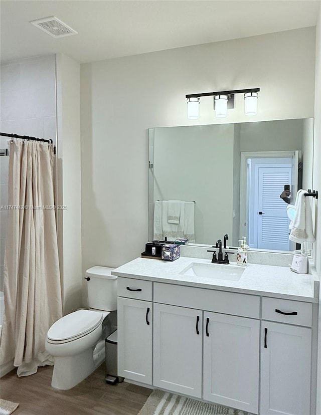 full bathroom featuring visible vents, vanity, toilet, and wood finished floors