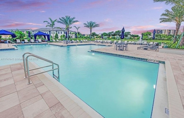 pool at dusk featuring a community pool, a patio, and a gazebo