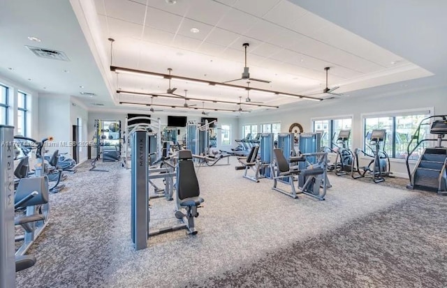 workout area featuring a tray ceiling and visible vents