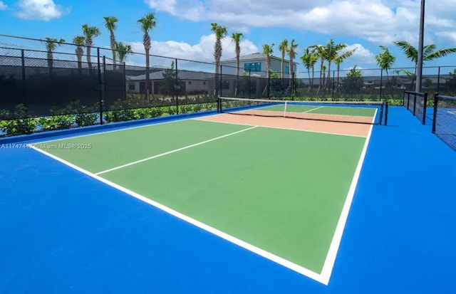 view of tennis court with community basketball court and fence