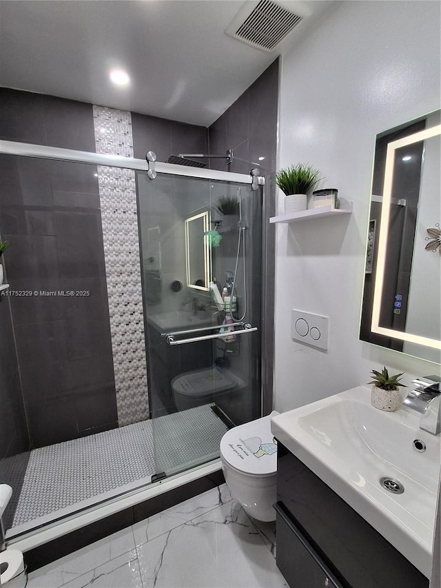 bathroom featuring marble finish floor, visible vents, toilet, a stall shower, and vanity