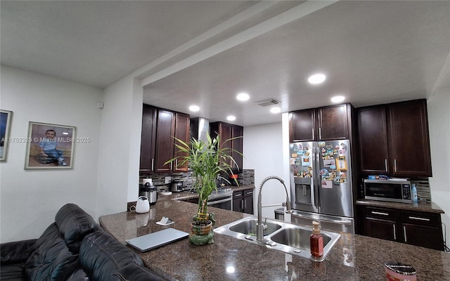 kitchen featuring visible vents, stainless steel appliances, a sink, and dark brown cabinetry