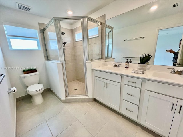 bathroom with visible vents, a sink, a shower stall, and toilet