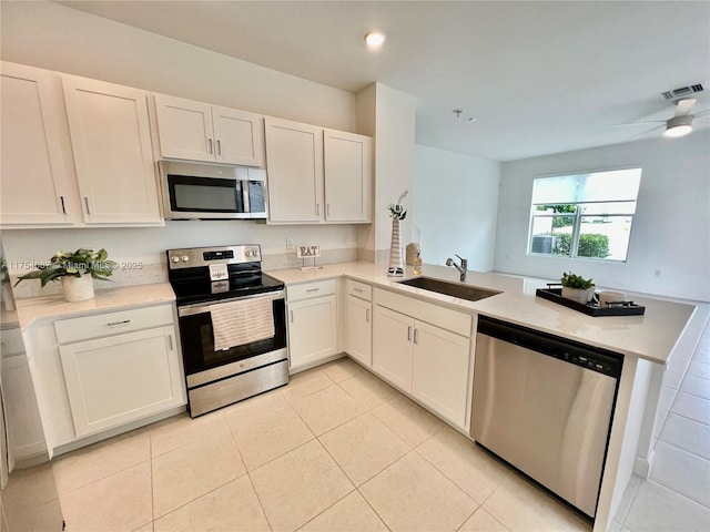 kitchen with stainless steel appliances, light countertops, visible vents, a sink, and a peninsula