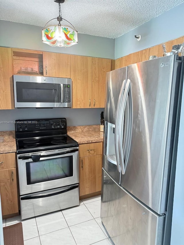 kitchen featuring light tile patterned floors, stainless steel appliances, a textured ceiling, light countertops, and pendant lighting