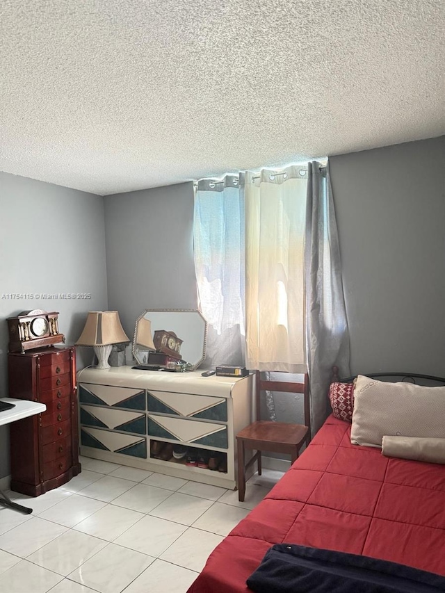 bedroom with a textured ceiling and light tile patterned floors