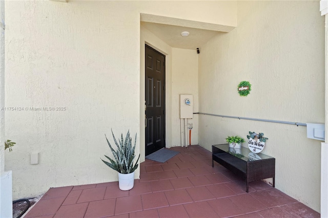 entrance to property with a patio area and stucco siding