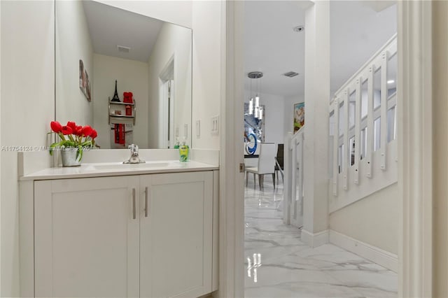 bathroom with marble finish floor, baseboards, visible vents, and vanity