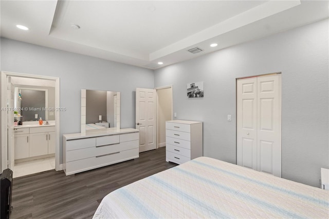 bedroom featuring a tray ceiling, dark wood-style flooring, visible vents, and recessed lighting