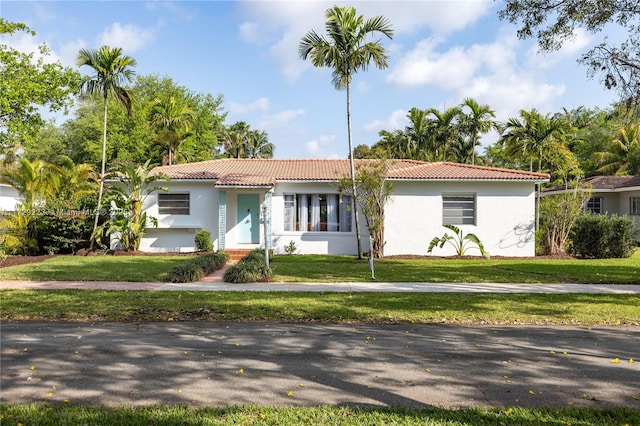 177 NE 109th St, Miami Shores, FL 33161 - view of front of home with a tiled roof, stucco siding, and a front lawn