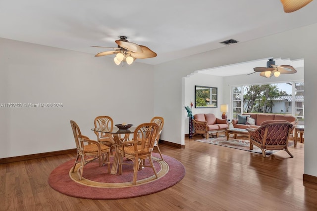 dining space with ceiling fan, wood finished floors, visible vents, and baseboards