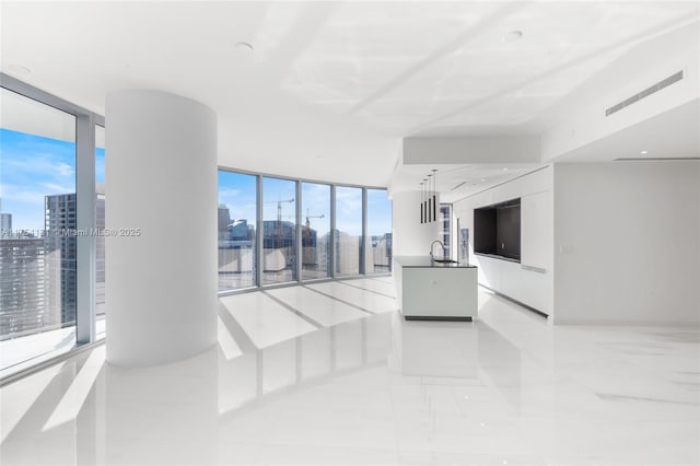 unfurnished living room featuring a wall of windows, a sink, and a city view