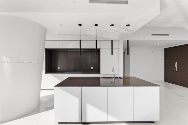 kitchen featuring marble finish floor, modern cabinets, visible vents, and a sink