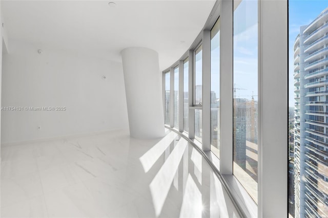 empty room featuring baseboards and floor to ceiling windows