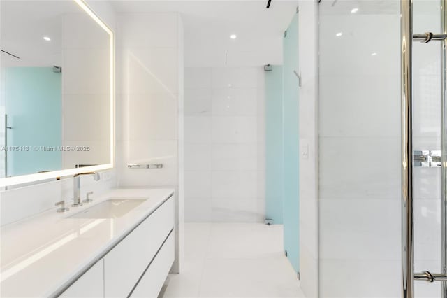 full bathroom with a tile shower, vanity, and tile patterned floors