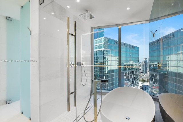 bathroom with a stall shower, a freestanding tub, tile walls, and a city view