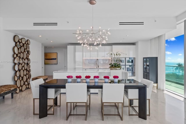 dining area featuring a chandelier and a wall of windows