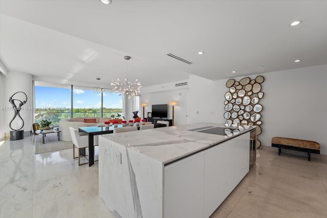 kitchen with open floor plan, white cabinets, modern cabinets, a wall of windows, and a large island with sink