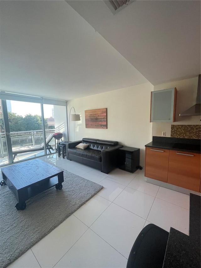 living room featuring floor to ceiling windows, light tile patterned flooring, and visible vents