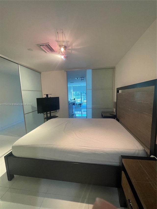 bedroom featuring tile patterned flooring, visible vents, and a ceiling fan