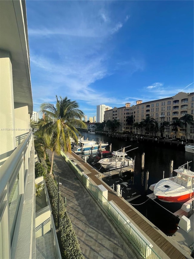 balcony featuring a dock, a water view, and a city view