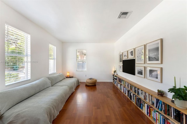 living room featuring baseboards, visible vents, and wood finished floors