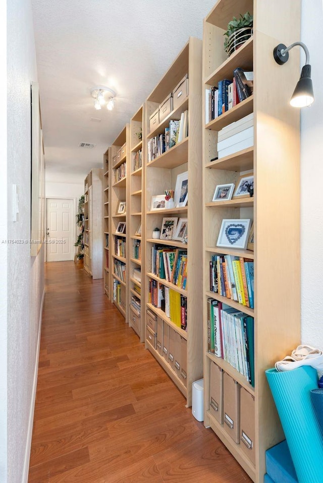 hallway with visible vents and wood finished floors