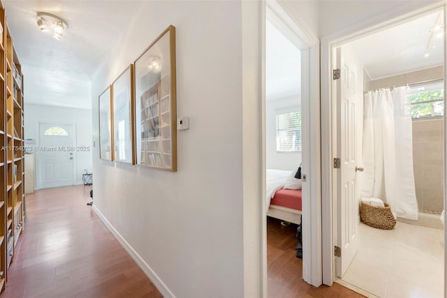 hallway featuring wood finished floors and baseboards